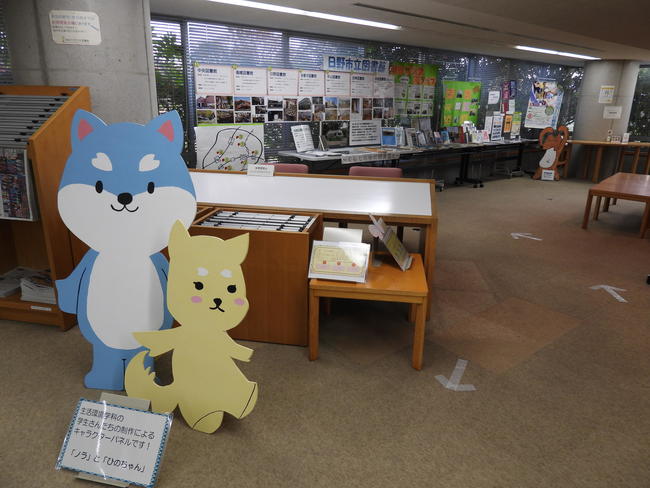 「ノラ」と「ひのちゃん」の木製スタンドと出張展示の写真